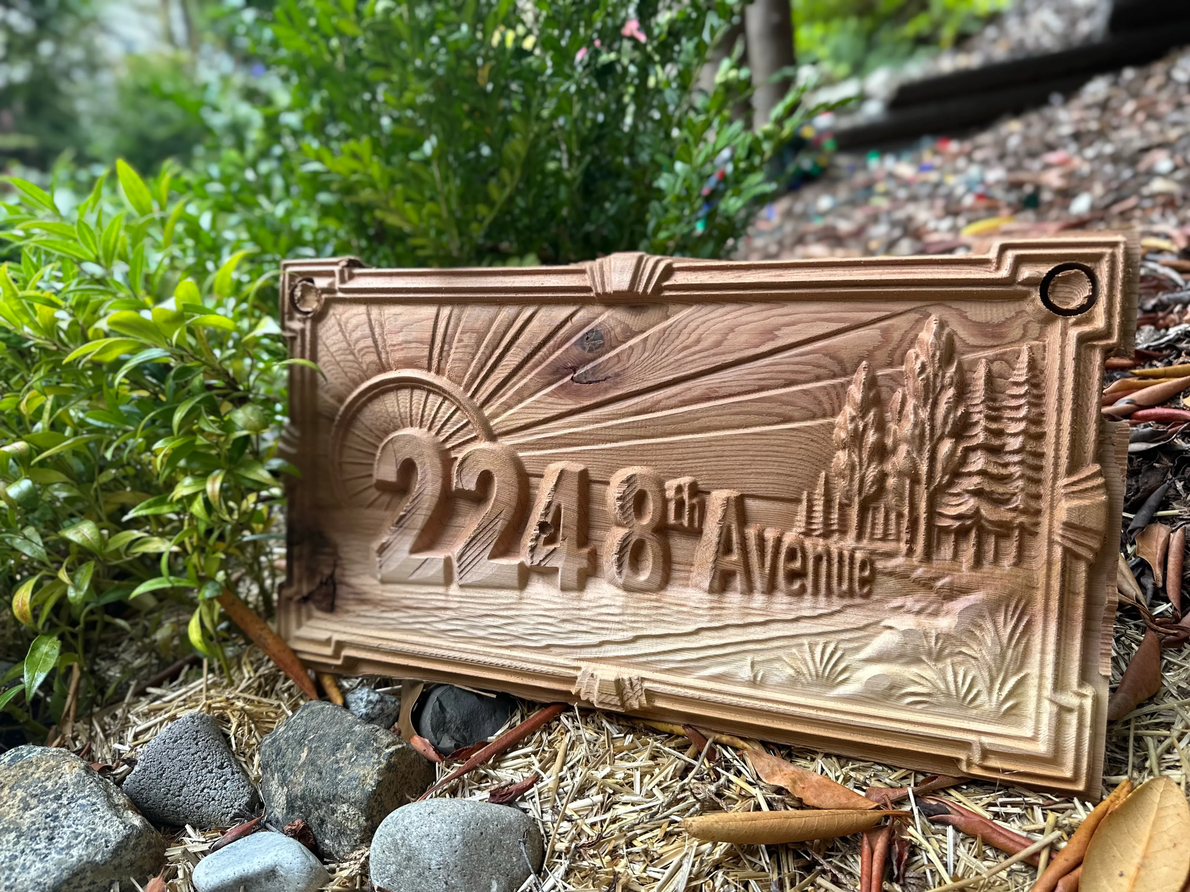 Sunburst Deco style: 2248 8th Avenue sign with a rising sun, stepped frame and evergreens